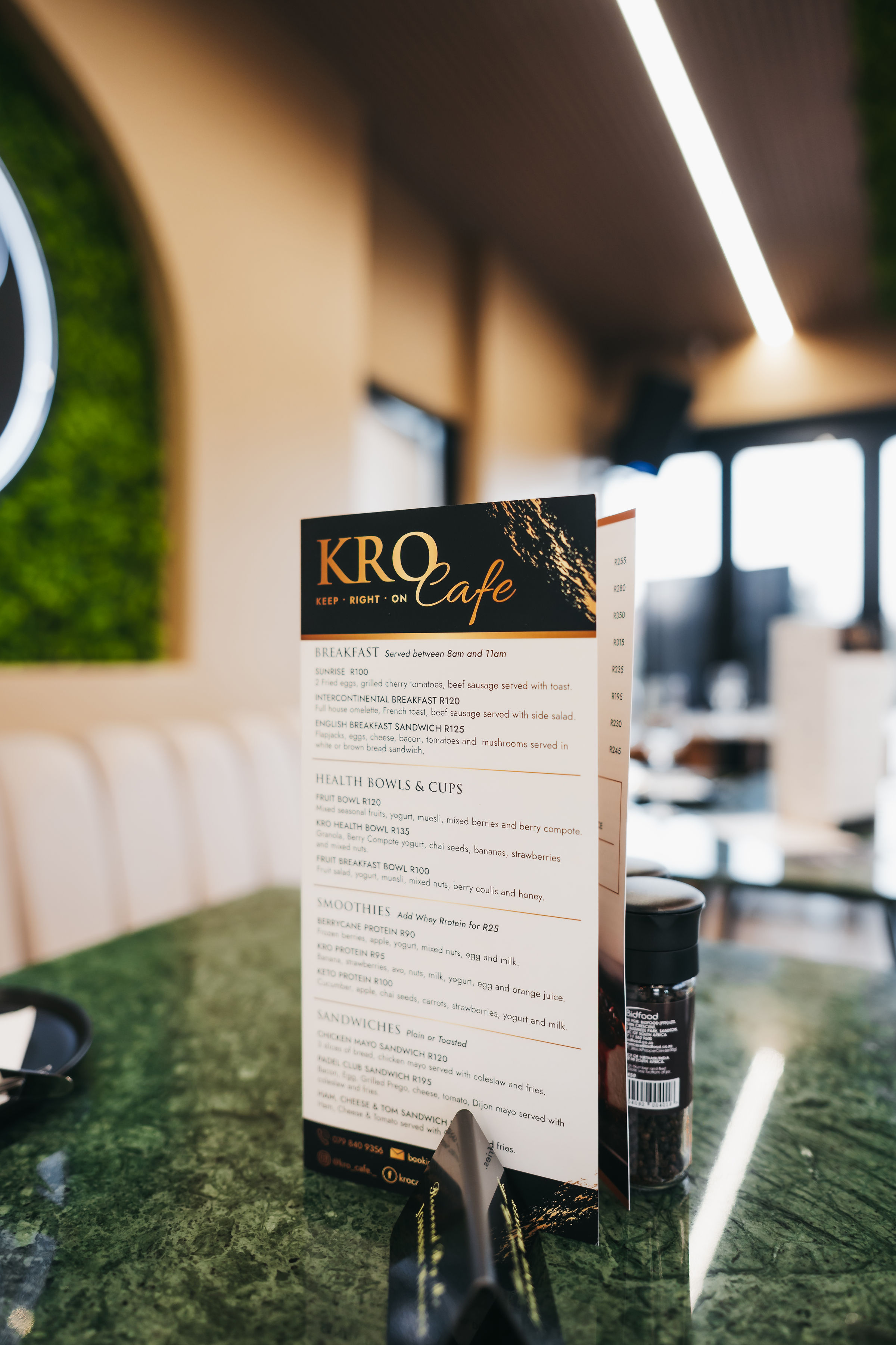 KRO Café printed menu on a green marble table