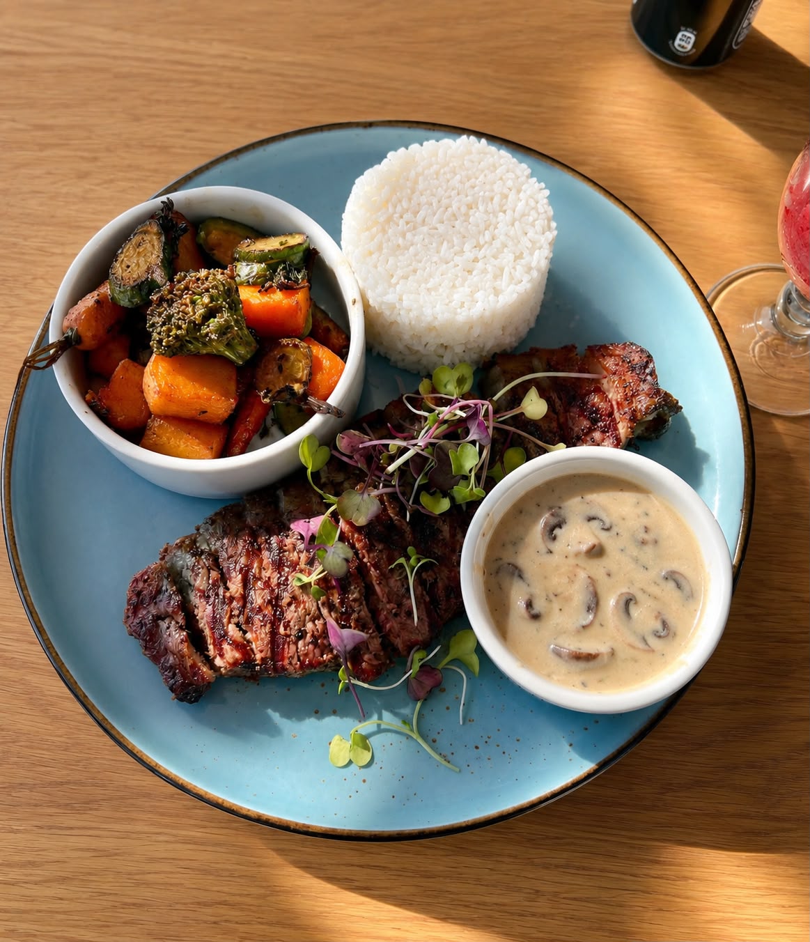 Grilled steak with rice, vegetables and mushroom sauce