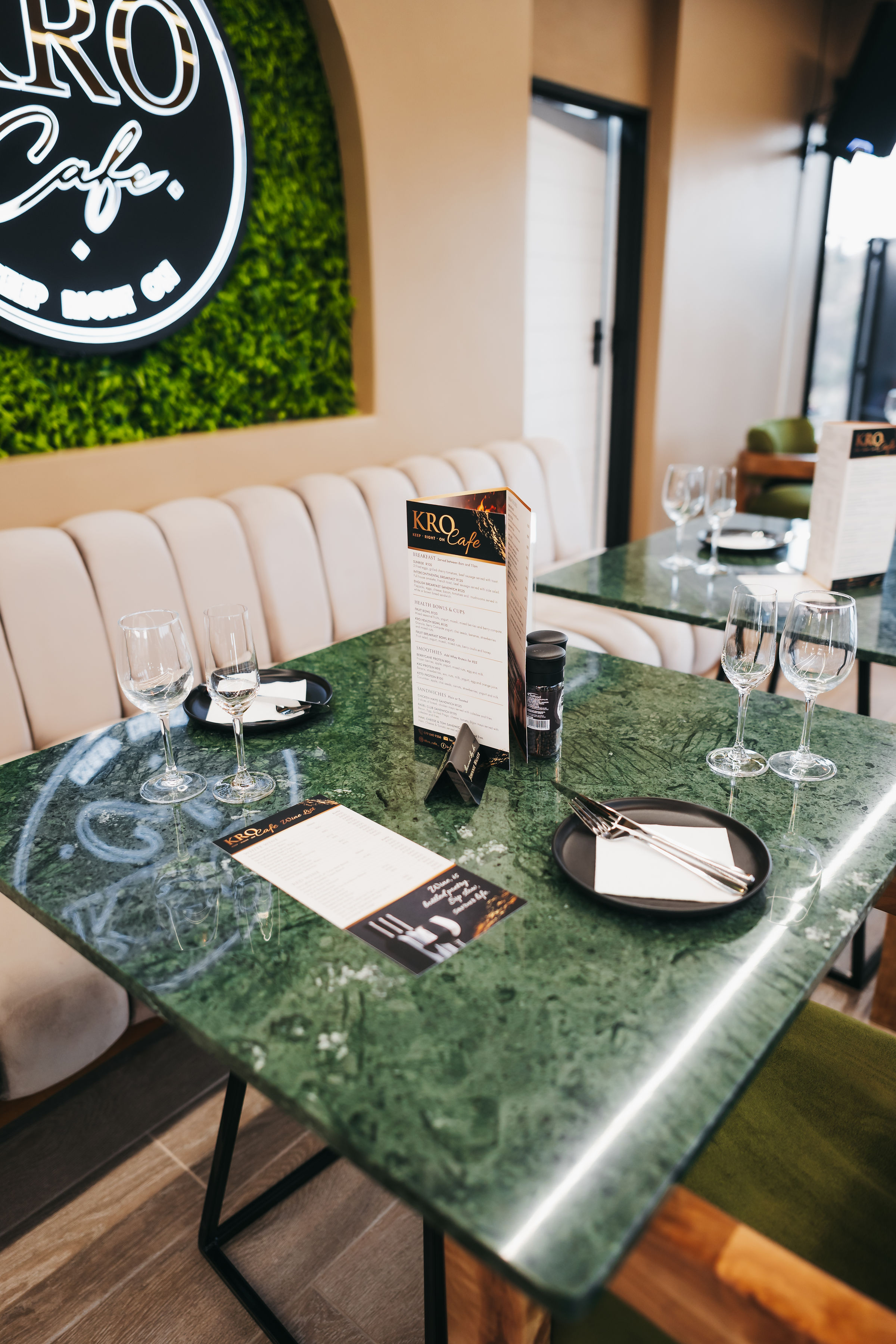 KRO Café green marble dining table with menus and glassware